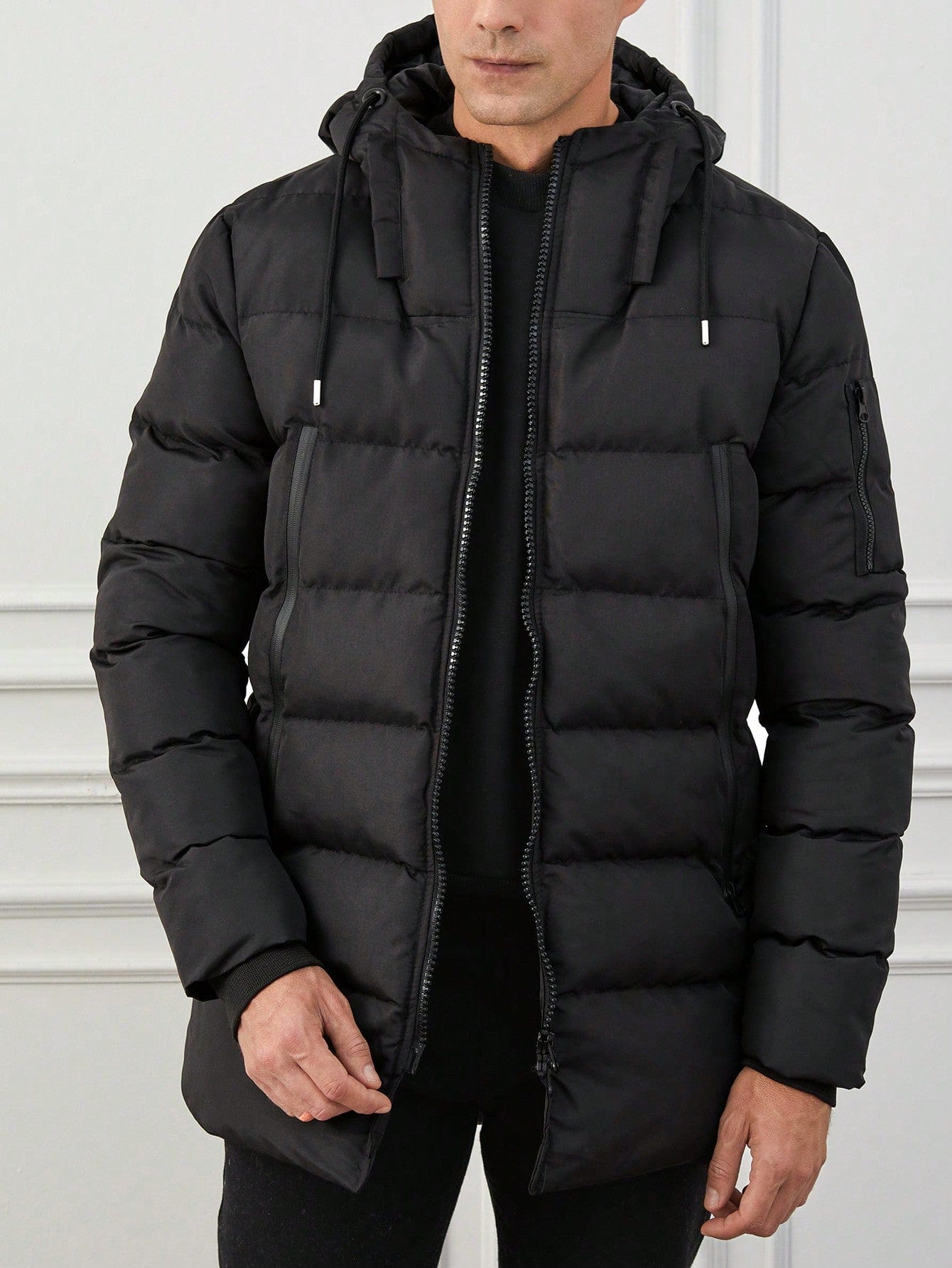 Herren-schwarze-gepolsterte-Winterjacke-mit-Kapuze-und-Reißverschluss-detaillierung-für-einen-schlichten-urbanen-Stil